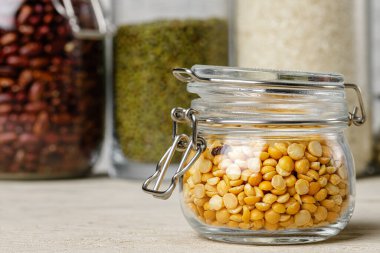 Cam kavanozlarda çiğ tahıl ya da fasulye var. Vejetaryen ve vejetaryen yemekleri.