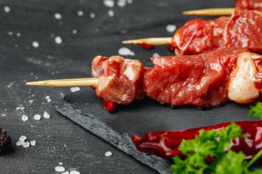 Karanlık bir tahtada çiğ biftek kebabı.