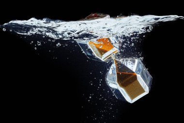 Kum saati siyah zemine karşı suya dalıyor