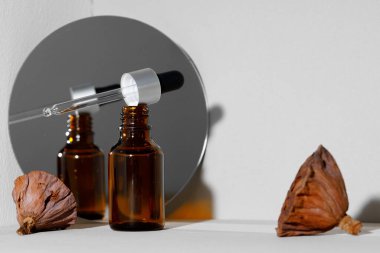 Cam kavanoz kozmetik yağı ve aynalı yaratıcı fotoğraf