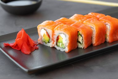 Philadelphia suşi rulosu siyah seramik tabakta servis edilir.
