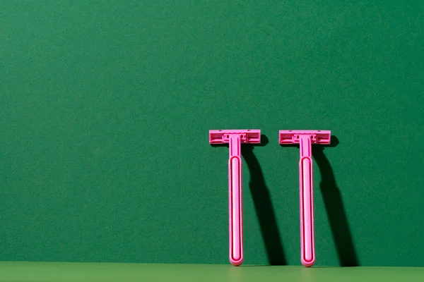 Disposable razor on green background, studio shot