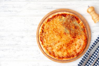 Tahta arka planda servis edilen dört peynirli pizza.