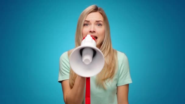 Блондинка молода жінка оголошує щось, використовуючи гучномовець на синьому фоні — стокове відео