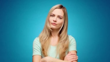 Sarışın kadın, parlak bir fikir üzerinde düşünüyor, düşünüyor, mavi arka plana karşı.