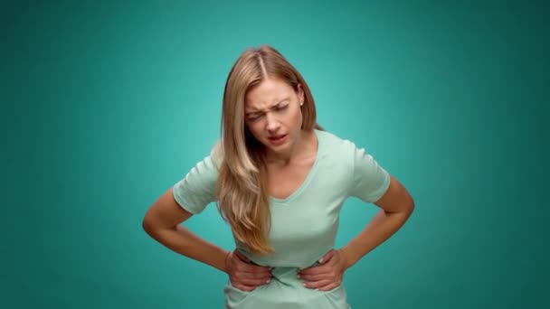 Hezká mladá žena trpí bolestí břicha, menstruační bolesti, proti mátové pozadí — Stock video