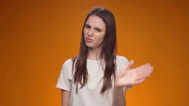 Displeased young woman covering eyes and gesturing stop against yellow background — Stock Video