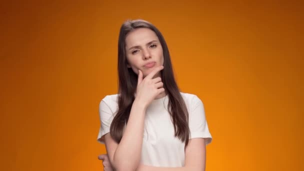 Blonde woman thinking over smart idea, pondering, against yellow background — Stock Video