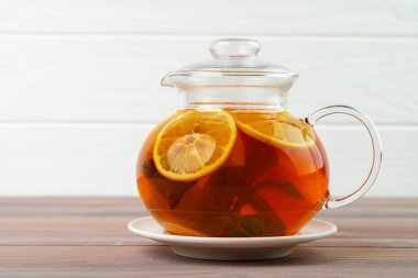 Siyah çay ve narenciye parçalı cam çaydanlık.