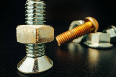 Siyah arka planda metal vidalar ve fındıklar