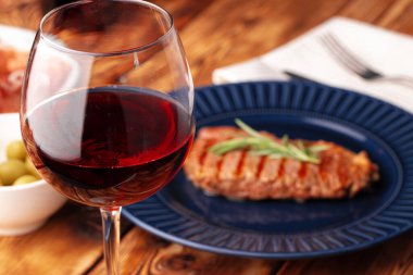 Mavi tabakta servis edilen ızgara biftek.