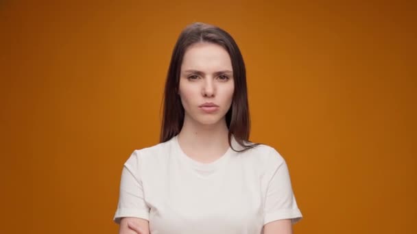 Mujer joven que expresa aversión, rechazo, actitud negativa contra el fondo amarillo — Vídeos de Stock