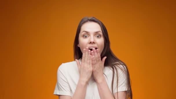 Retrato de mujer sorprendida y conmocionada sobre fondo amarillo — Vídeos de Stock