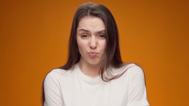 Young woman expressing aversion, rejection, negative attitude against yellow background — Stock Video
