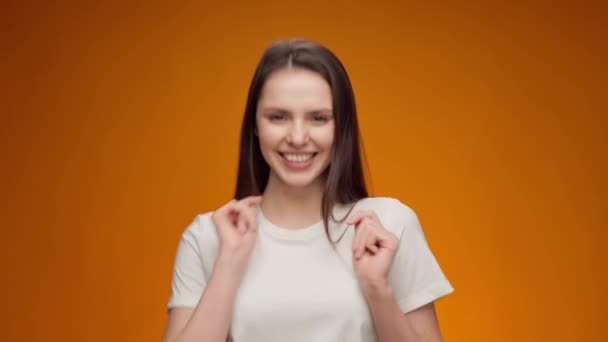 Gelukkig jong vrouw dansen met vreugde tegen geel achtergrond — Stockvideo