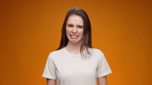 Jonge vrouw uiten afkeer, afwijzing, negatieve houding tegen gele achtergrond — Stockvideo