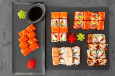 Gri arka planda servis edilen suşi ruloları.