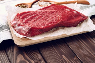 Kahverengi tahta üzerinde çiğ et filetosu.