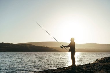 Gölde oltayla balık tutan balıkçı.