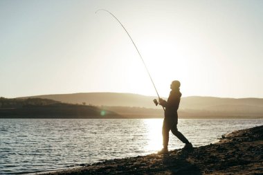 Gölde oltayla balık tutan balıkçı.