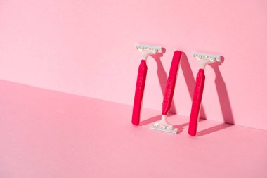 Pembe arka planda tek kullanımlık jiletler, kopyalama alanı