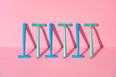 Pembe arka planda tek kullanımlık kadın jiletleri, stüdyo çekimi.