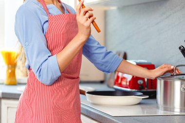 Tanımlanamayan bir kadın mutfakta dikiliyor.