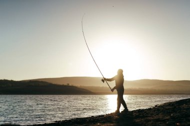 Gölde oltayla balık tutan balıkçı.
