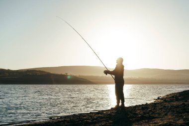 Gölde oltayla balık tutan balıkçı.