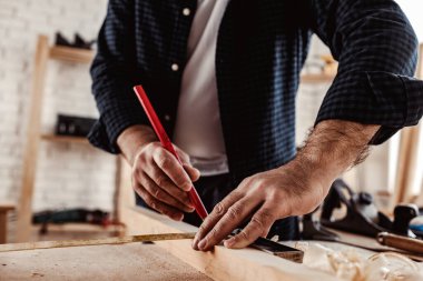 Marangoz tahta üzerinde kalem izleri yapar.