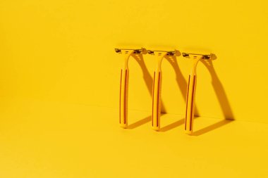 Sarı arka planda tek kullanımlık jiletler, stüdyo çekimi.