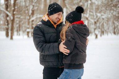 Genç ve mutlu bir çift kış parkında yürüyüş yapıyor.