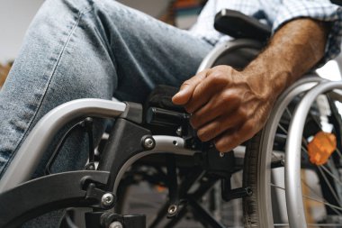 Tekerlekli sandalyede oturan tanınmayan engelli adam.