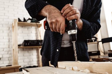 Bir marangozun keresteye delik açmasına yakın.