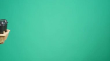 İnsanlar birbirlerine kahve tepsisi uzatıyor. Stüdyo arka planda.