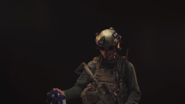 Special forces soldier standing in the dark and raising up USA national flag — Stock Video