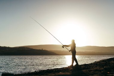 Gölde oltayla balık tutan balıkçı.