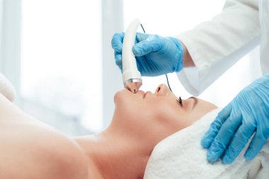 Güzel bir kadın kozmetik güzellik kliniğinde yüz bakımı yaptırıyor.