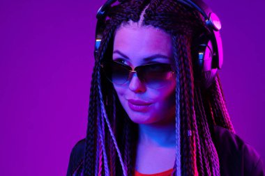 Uzun saçlı güzel bir kadın kulaklıkla müzik dinliyor.