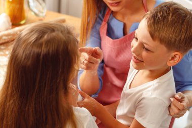 Kadın ve çocukları mutfakta yemek pişiriyor.