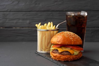 Lezzetli hamburger ve patates kızartması tahtada siyah arka planda