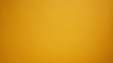 Eldivenli kurye, sarı arka planda teslimatı olan el sanatları çantasından geçiyor.