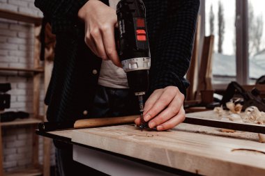 Bir marangozun keresteye delik açmasına yakın.