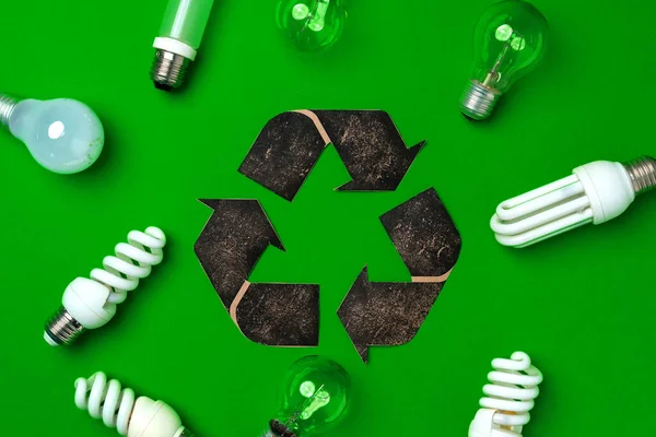 Light bulb and recycling sign on green background