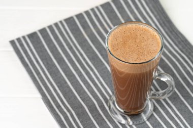 Cam bardak kakao, beyaz ahşap masada içecek.