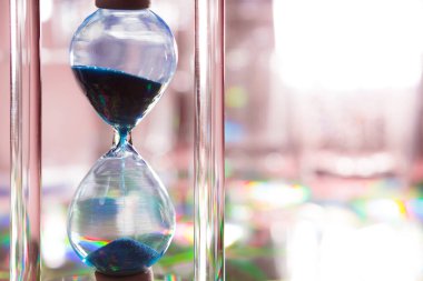 Gri arkaplanda mavi kum saati. Yakın plan.