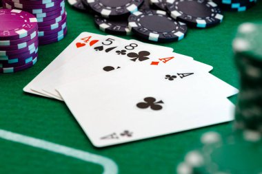 Yeşil kumarhane arka planında kart ve fiş oynamak