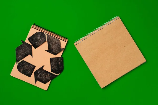 Paper recycling concept on green background top view