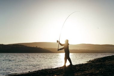 Gölde oltayla balık tutan balıkçı.