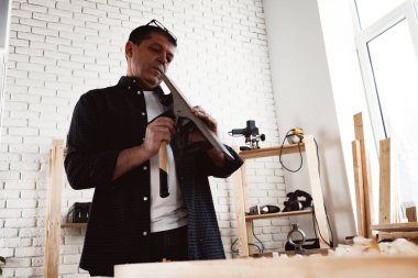 Marangozların elleri el uçağıyla bir tahta döşeme yapıyor.